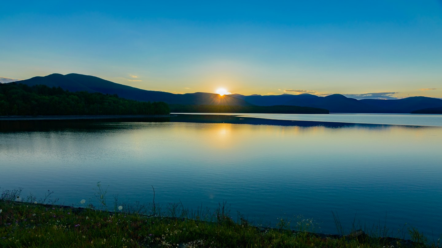 Sunset reflected on Ashokan Reservoir with Catskill Mountains on the horizon