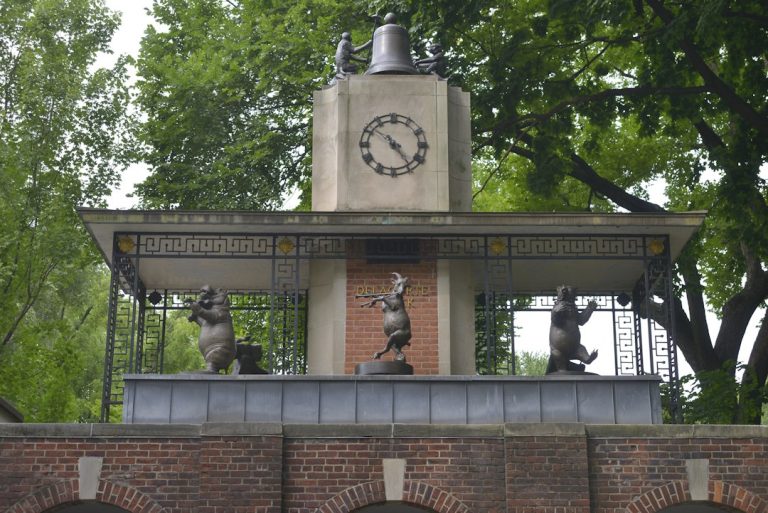 The Delacorte Clock and its animal sculptures beside leafy trees at Central Park Zoo