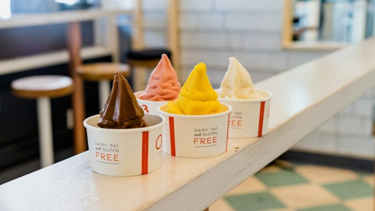 Four colorful cups of frozen dessert on a counter; illustrative food photograph