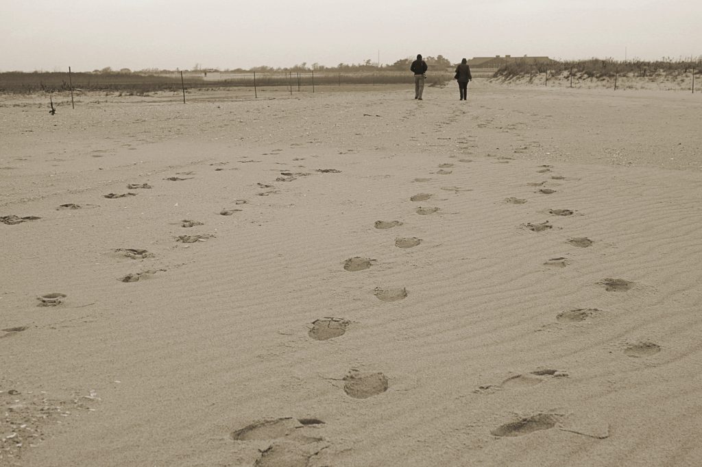 Footprints and walkers on the sand at Jones Beach State Park