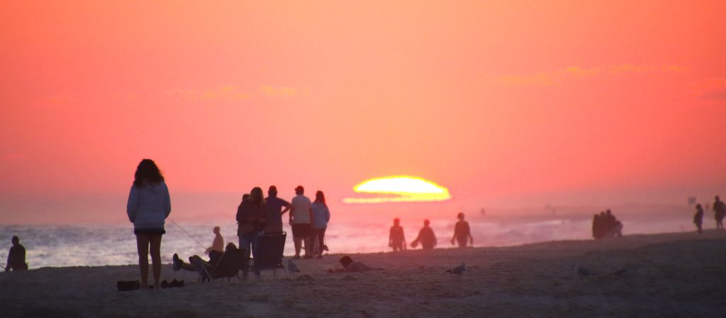 A glowing sunset and silhouettes along the Jones Beach shoreline