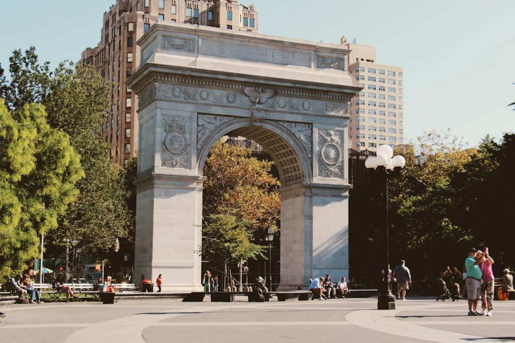 Washington Square Arch with people walking through the park