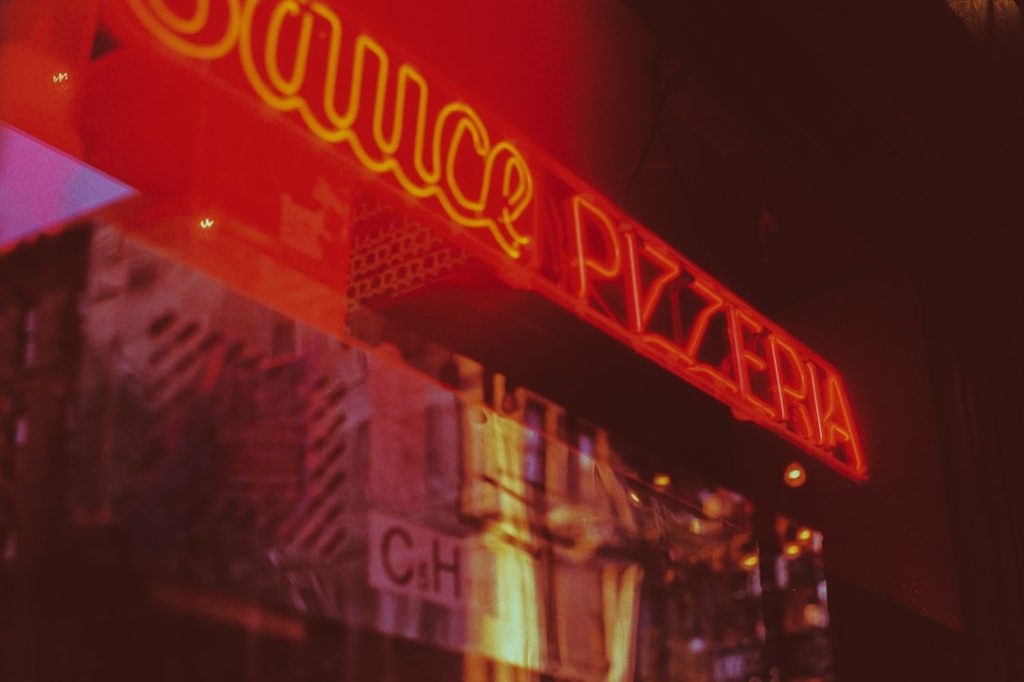 A neon pizzeria sign photographed on the Lower East Side