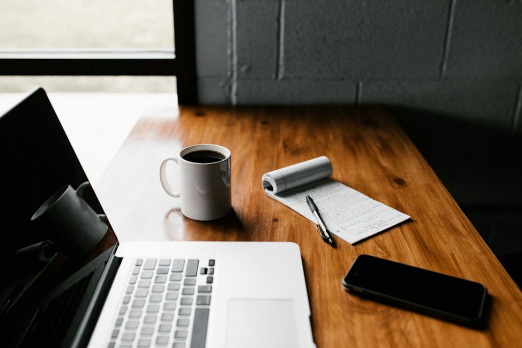 Laptop and notebook on a workspace table, illustrative stock photograph