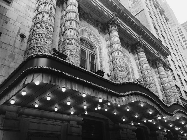 Ornate columns and an illuminated canopy at a theater in New York’s Theater District