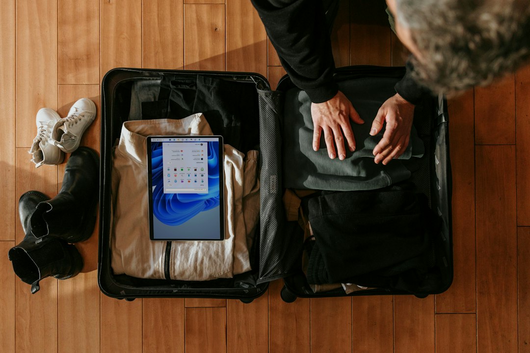 A person organizing an open suitcase and a backpack