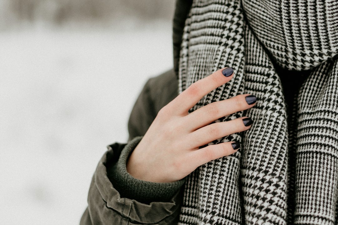 A patterned winter scarf wrapped around a coat; winter layering inspiration
