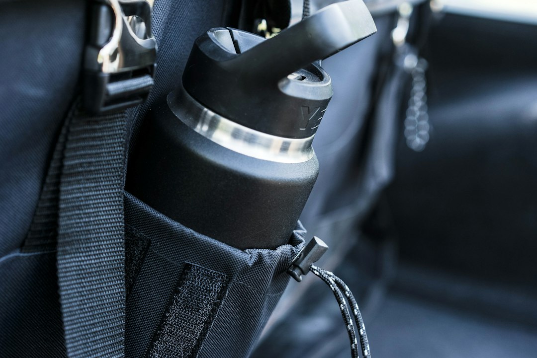 A water bottle tucked into the side pocket of a backpack