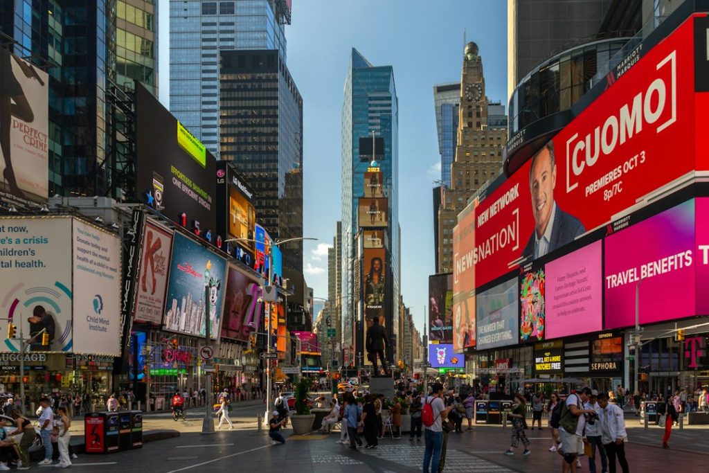 People and yellow taxis among the bright signs of Times Square